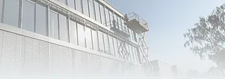 Gebäudefassade mit großen Fenstern und einem Arbeitskorb an einem Hebebühnenarm